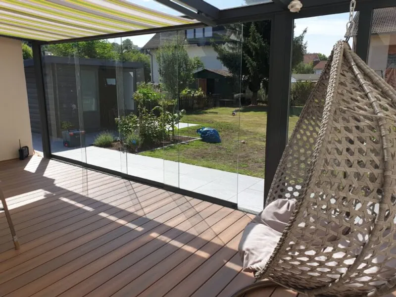 Terrassenüberdachung mit Glasfront und Sitzbereich