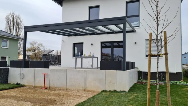 Terrassenüberdachung mit Glaseindeckung an einem Wohnhaus