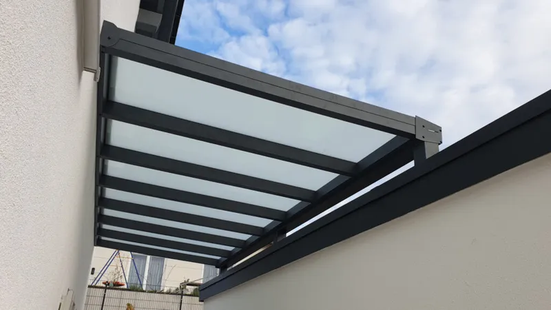 Detailaufnahme einer Aluminium-Überdachung mit opaler Glaseindeckung